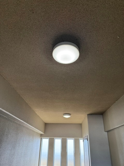 市営住宅の共用部に取り付けられた丸型照明器具の近景