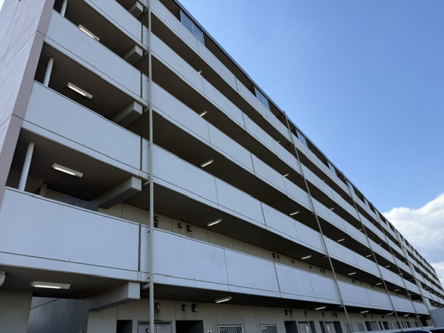 市営住宅の外観と各階の共用廊下に並ぶ照明器具